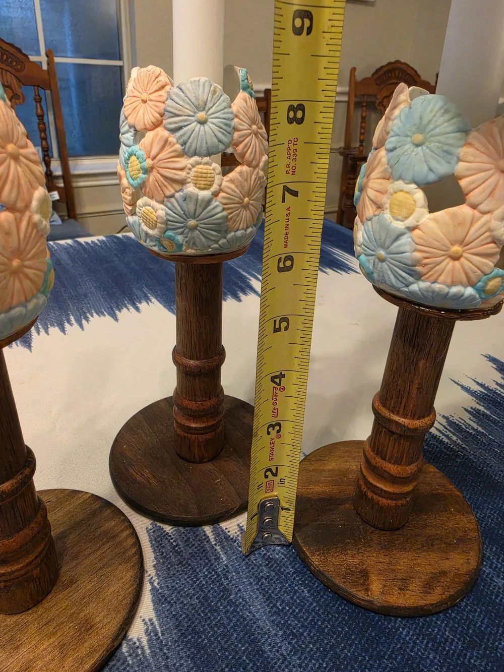 Trio Of Turned dark wood candlestick holders pastel-colored sculpted floral cups